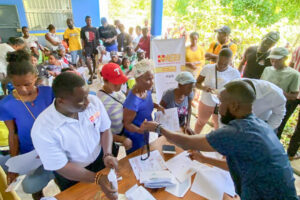 Des bénéficiaires reçoivent une assistance financière lors d’une activité de distribution organisée par ASB à Port-Salut.