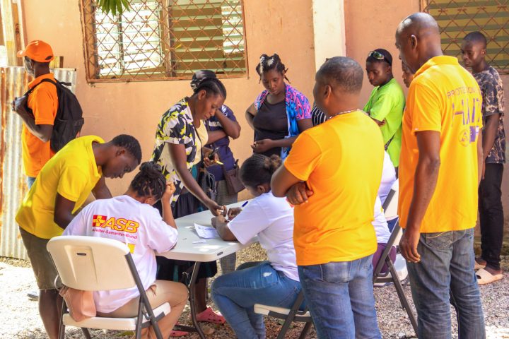 ASB team members register beneficiaries during a food kit distribution in Camp-Perrin.